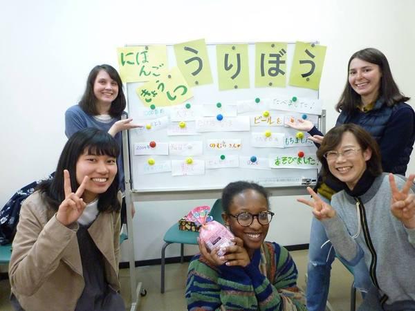 にほんごきょうしつうりぼうと書かれたホワイトボードの前で5人の外国の女性の方が笑顔でピースをしている写真