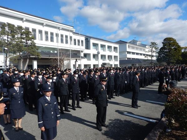 制服姿の消防団員と消防職員らが建物の前で整列している写真