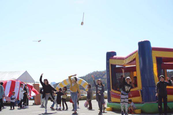 ひしゃくを勢いよく放り投げて競い合っている写真