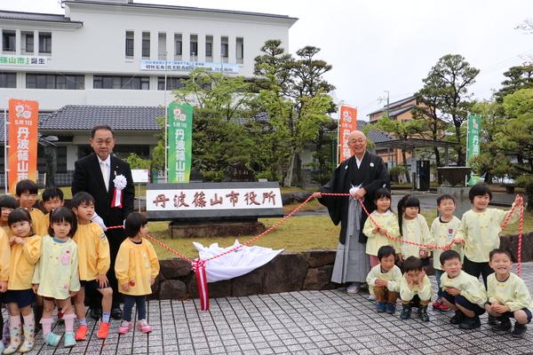 園児たちと一緒に除幕式をしている市長の写真