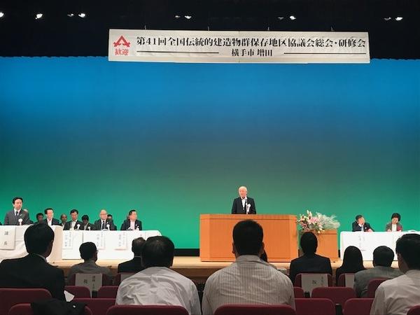 舞台で市長が話をして、参加者が話を聞いている写真