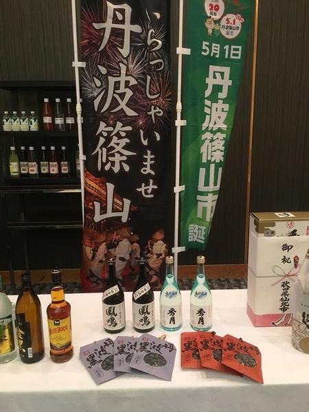 丹波篠山の旗が2本立てられ、テーブルの前にはお酒が紹介されている写真