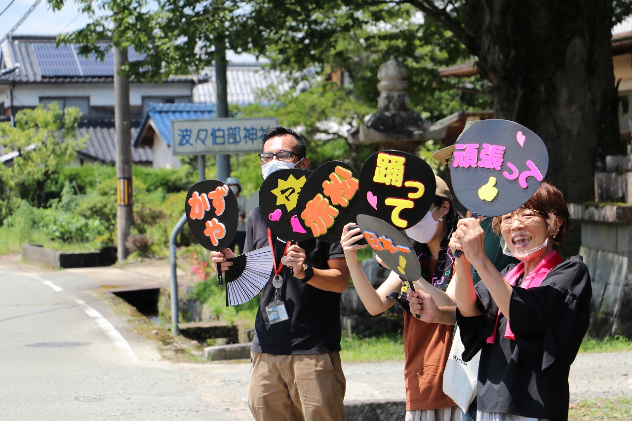 沿道にあかまっちゃんの応援にかけつけた同級生3人手には「かずや」「赤松」「踊って」「頑張って」という応援うちわを持っている