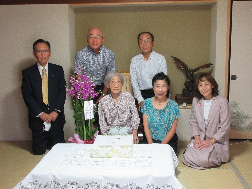 宮本さんを囲んで、ご家族と市長、市関係者が記念撮影
