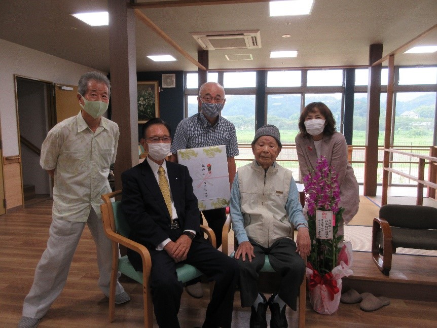 波部さんを囲んで、市長、市関係者が記念撮影