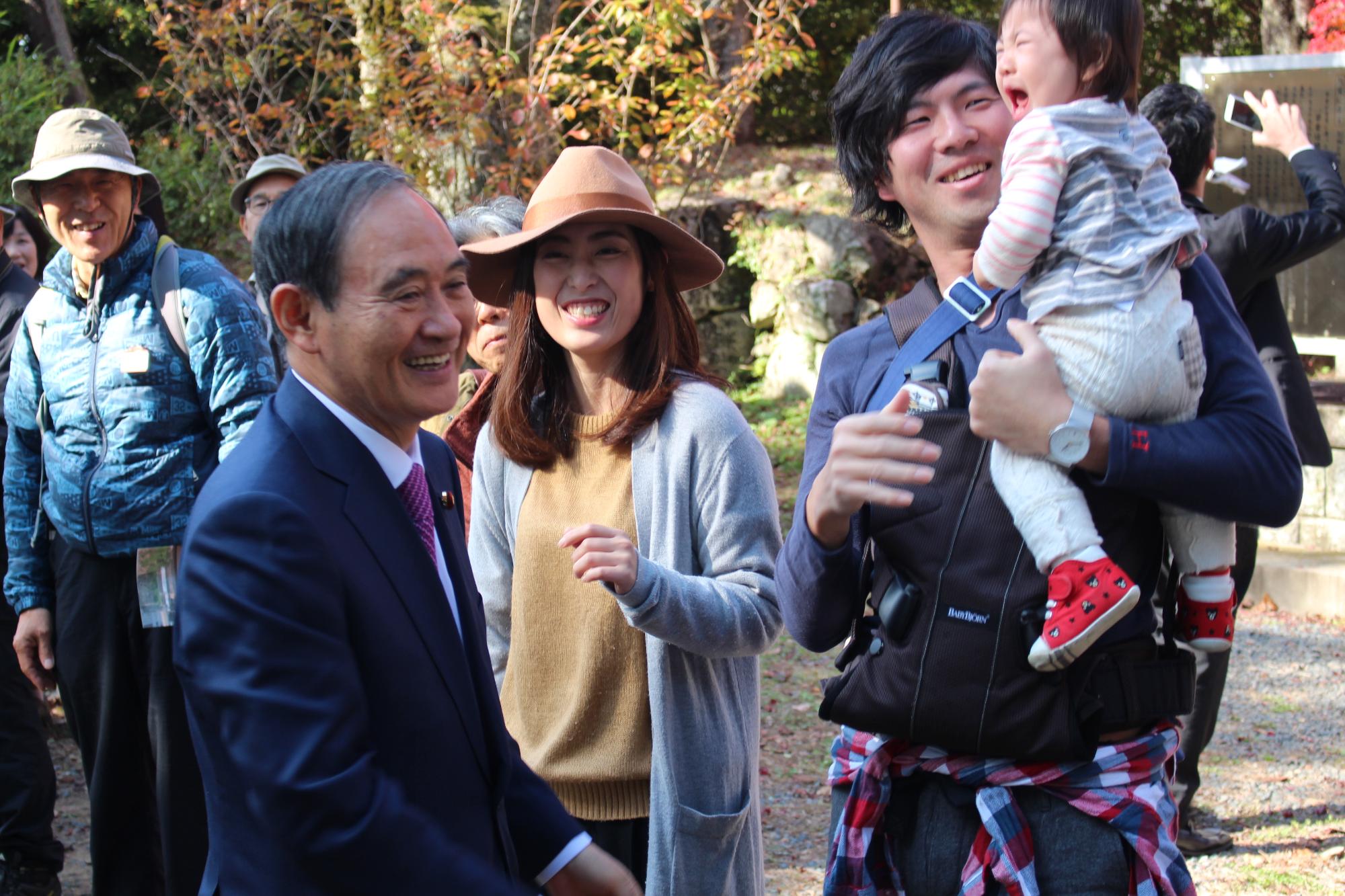 菅さんと、泣いている赤ちゃんを抱っこする旦那さん、奥さん