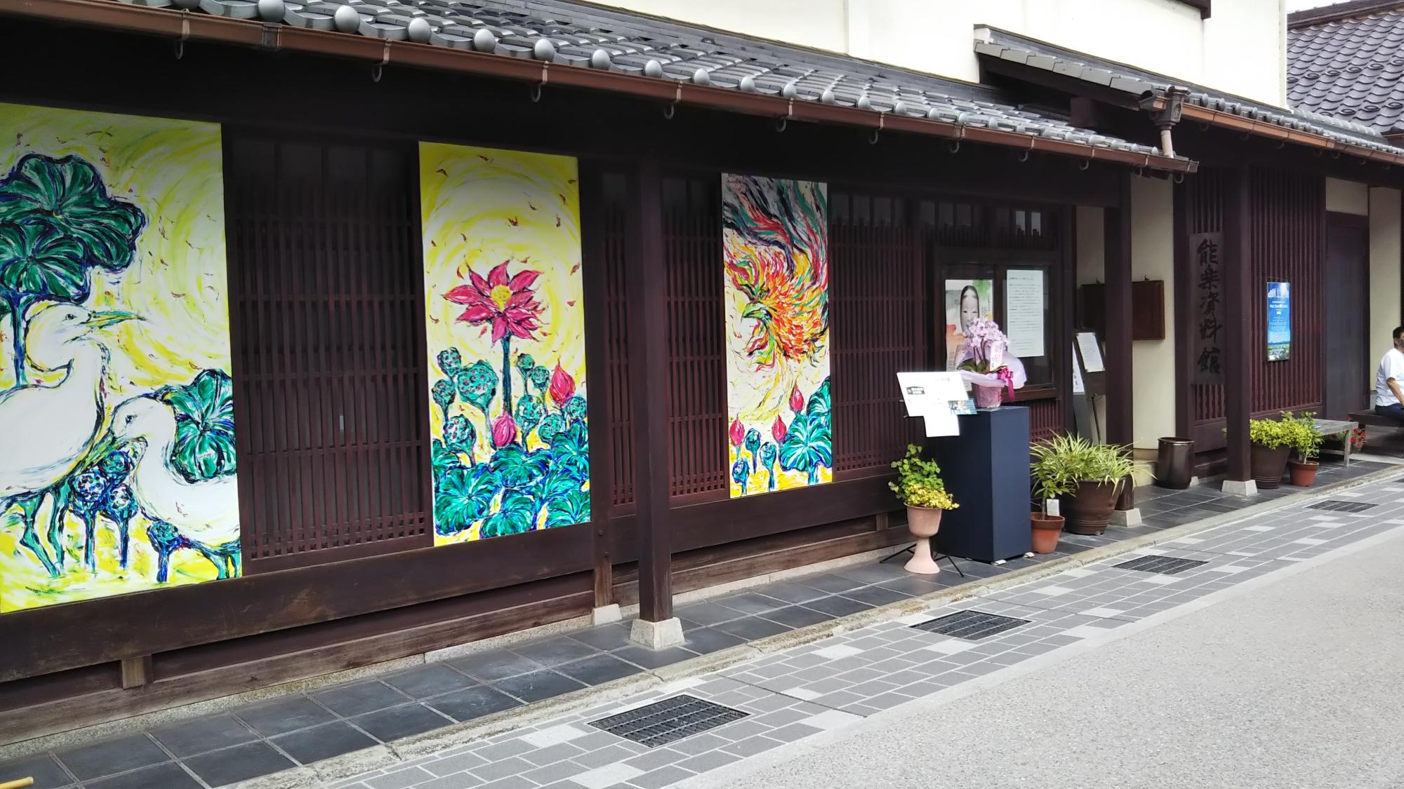 町家の外溝に花や鳥の絵画が3枚飾ってある。