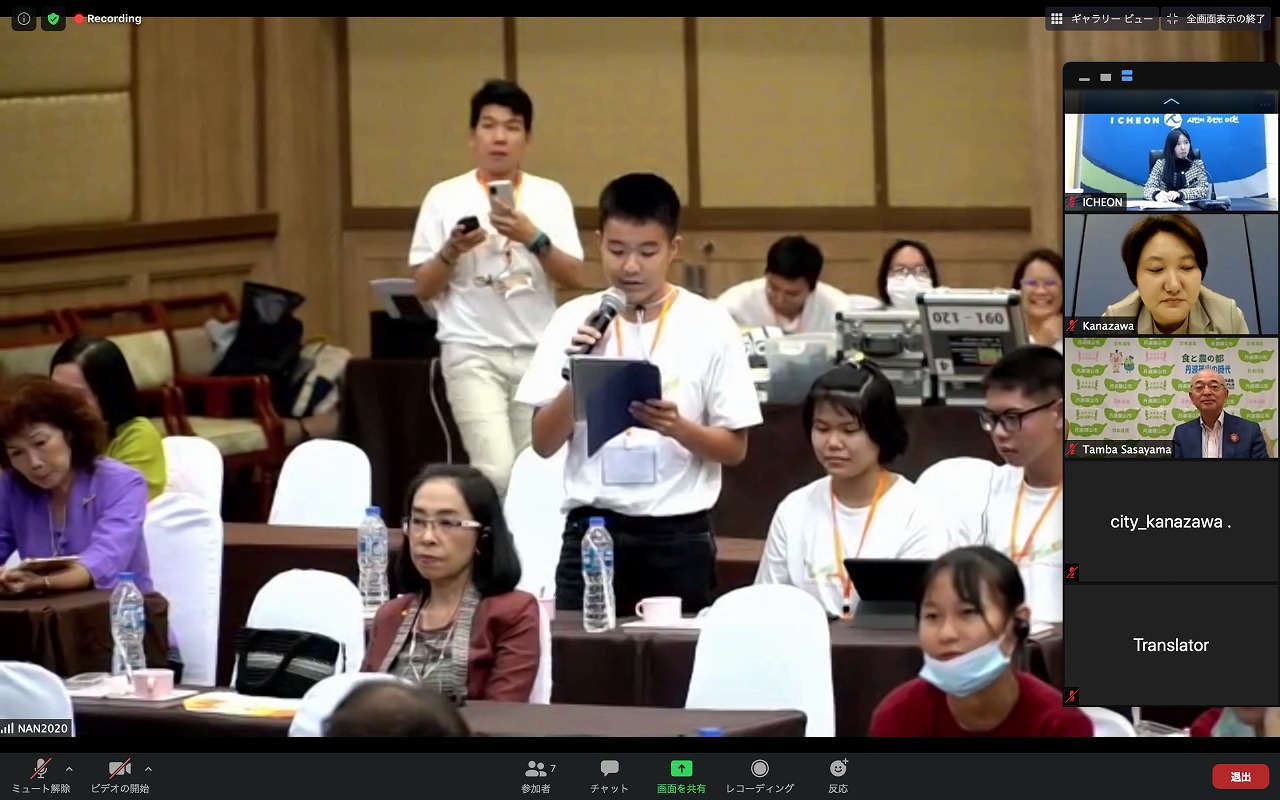 現地会場でスピーチしている様子と、それを確認している参加者の様子が映し出されている