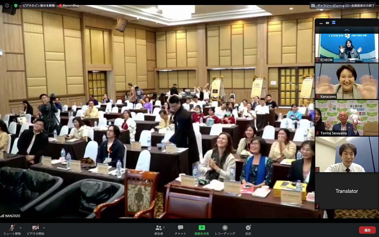 フォーラムが終了し、会場の方が拍手している。オンライン参加者が画面越しに手を振っている。
