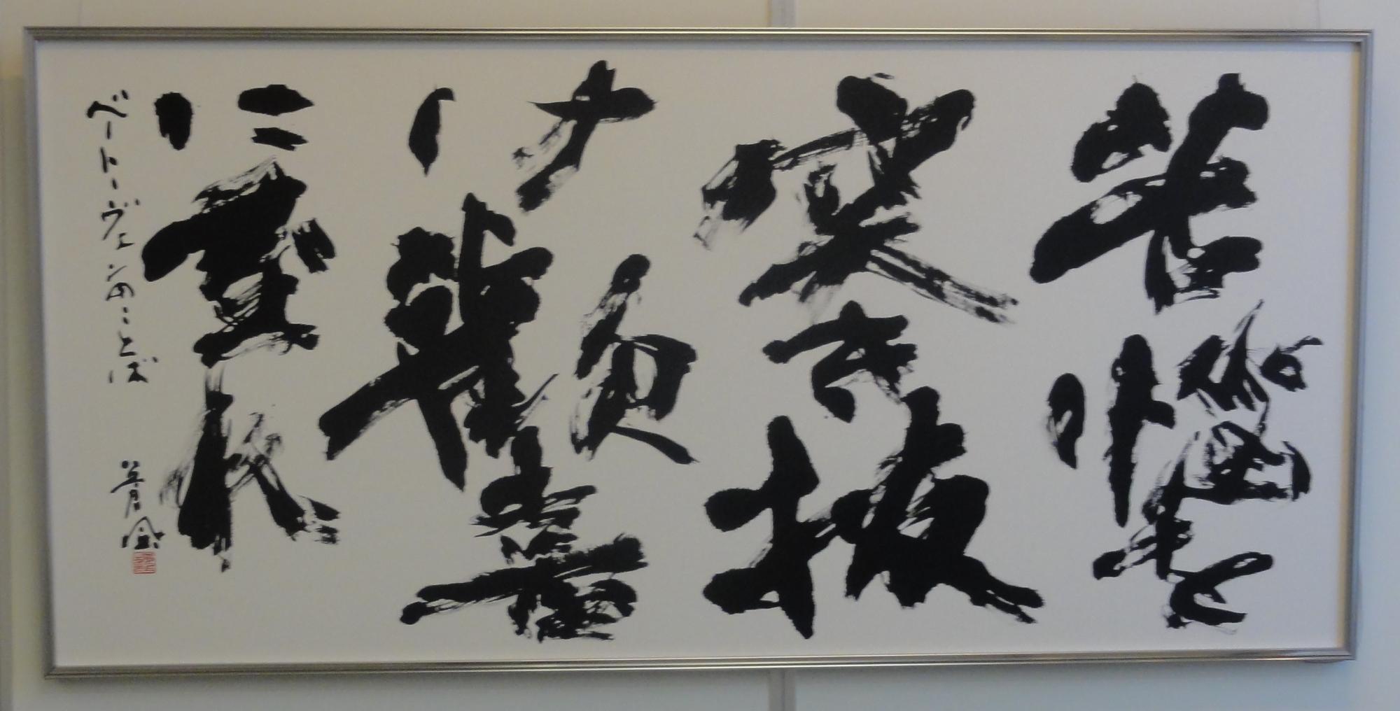 書道の作品。ベートーヴェンが残した「苦難を突き抜けて歓喜に至れ」ということばを横長の半紙に書いている。