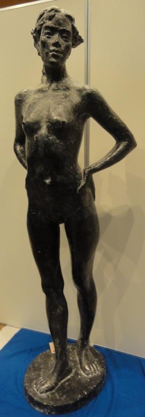 彫刻の作品。女性が両腕を腰にあてて立っている