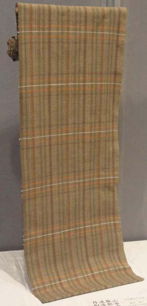 織物の作品。オレンジとベージュを基調にしたタータンチェックの布。