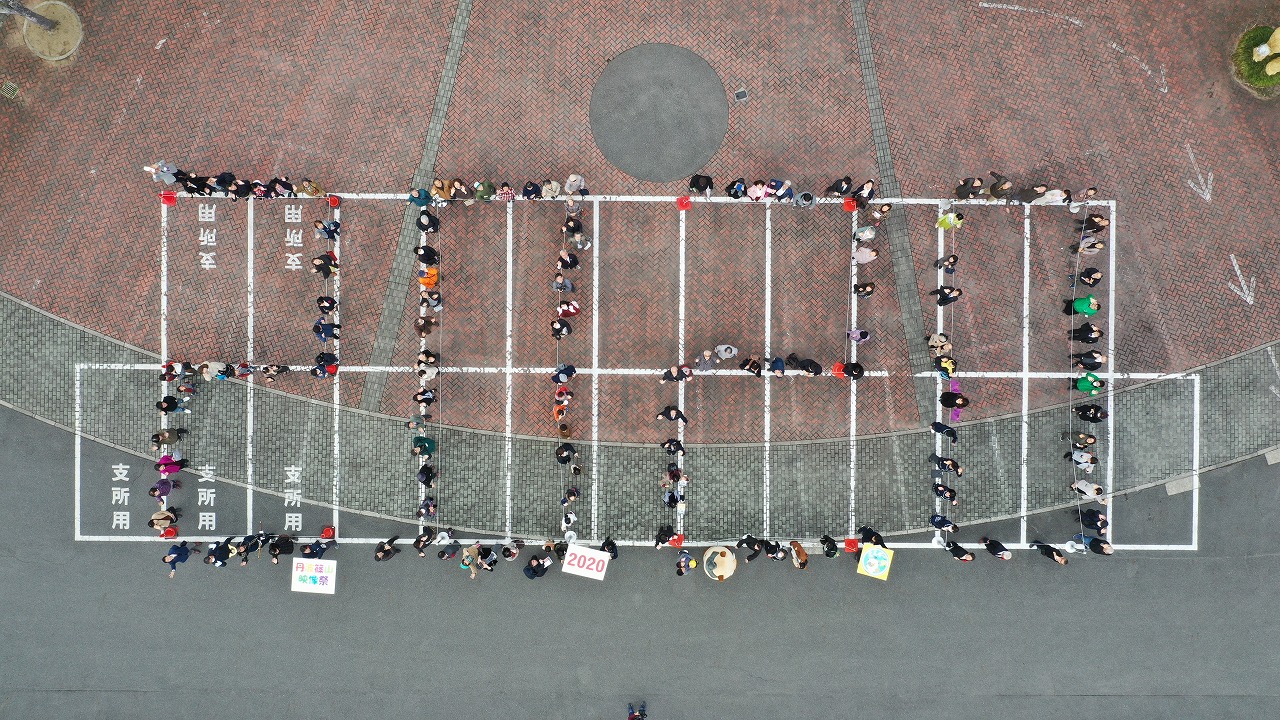 駐車場にて、上から2020の人文字を撮影した写真