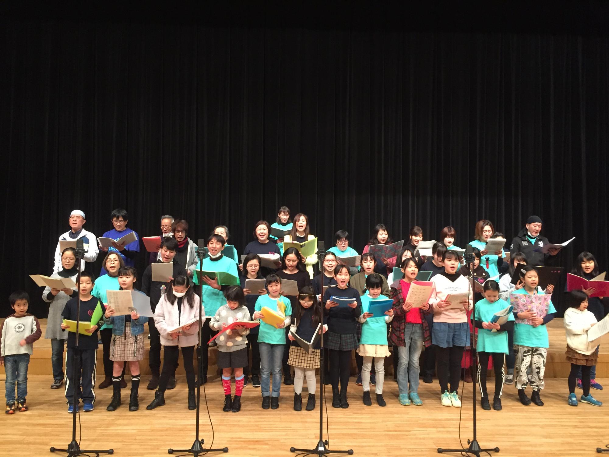 出演者の方たちが、舞台上で横3列に並び、台本をみながら声を出している写真