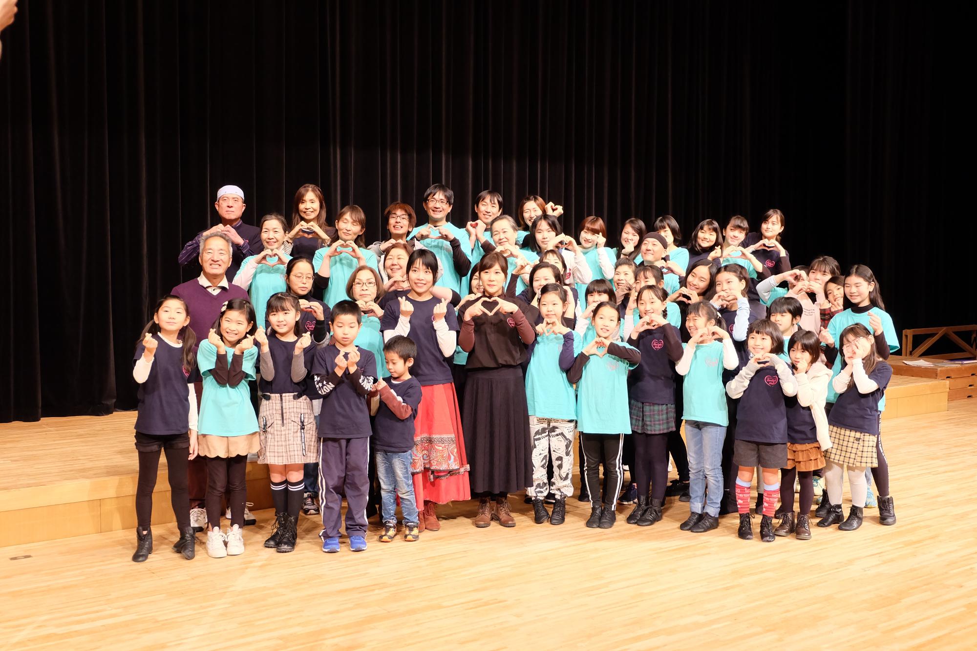 指や手でハートの形を作って写真撮影をする出演者の方々など