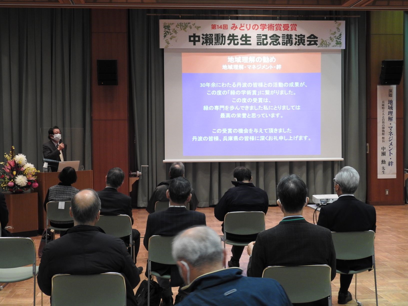 中瀬先生がスクリーンを使って講演をされている。