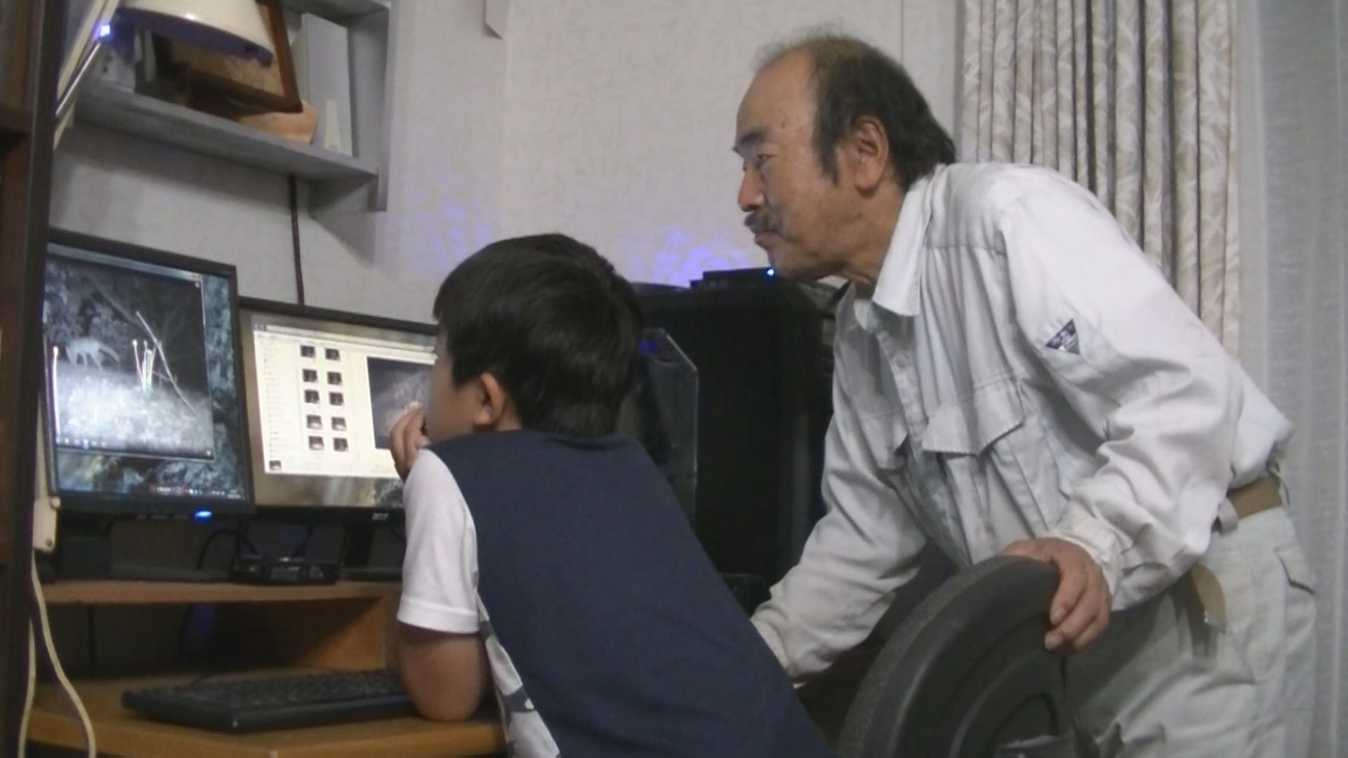 谷口氏とお孫さんが、野生動物の映像を見ている