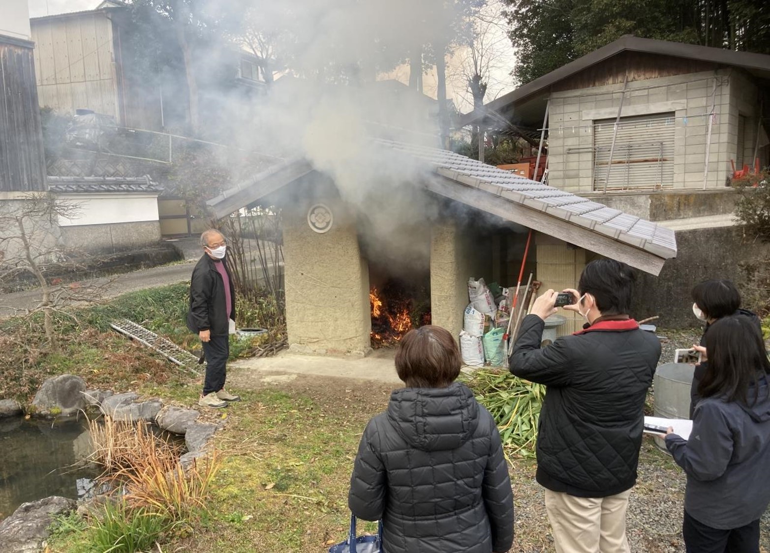 現地で、調査員の方に灰小屋の説明をされている地元の方。