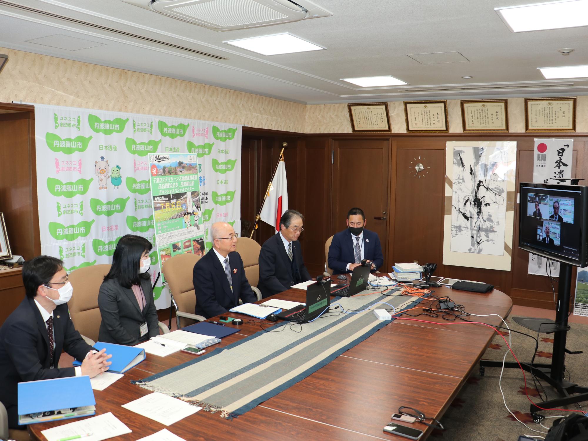 オンラインで契約を締結している様子。机のパソコンとモニターを見ながらやりとりしている様子。