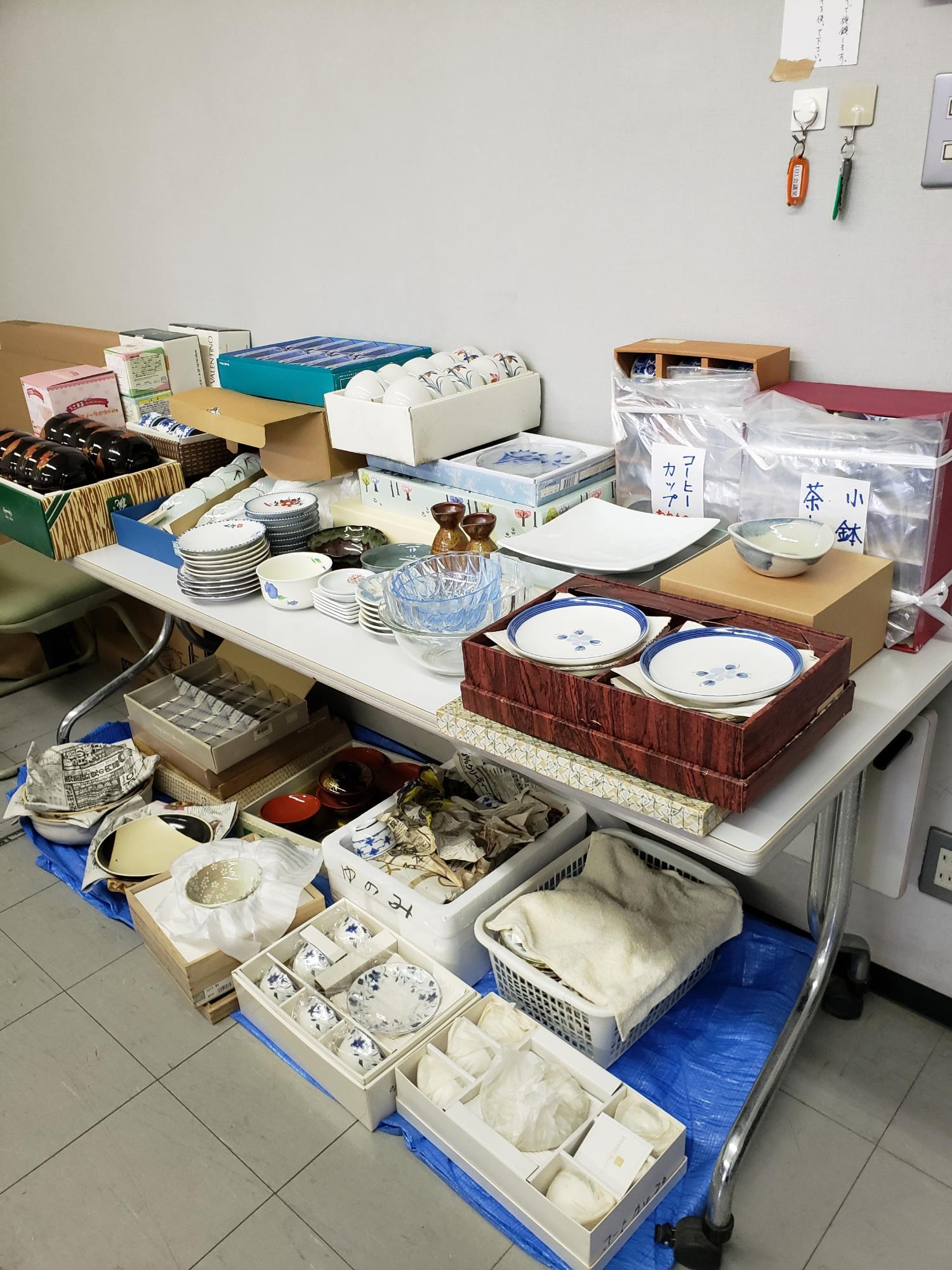 机や床に湯のみや食器がたくさん並んでいる