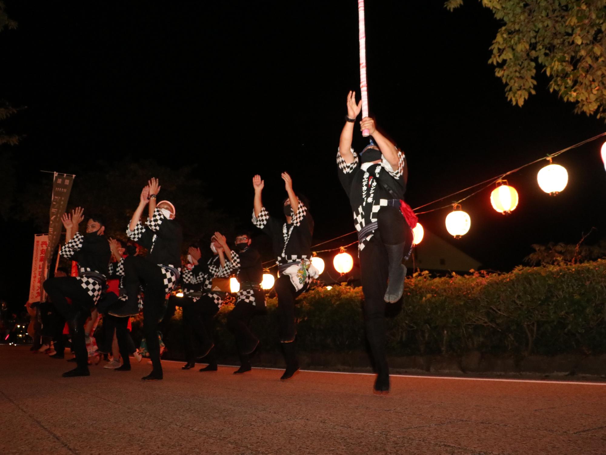 黒いハッピをきた男性10数名がデカンショを踊っている