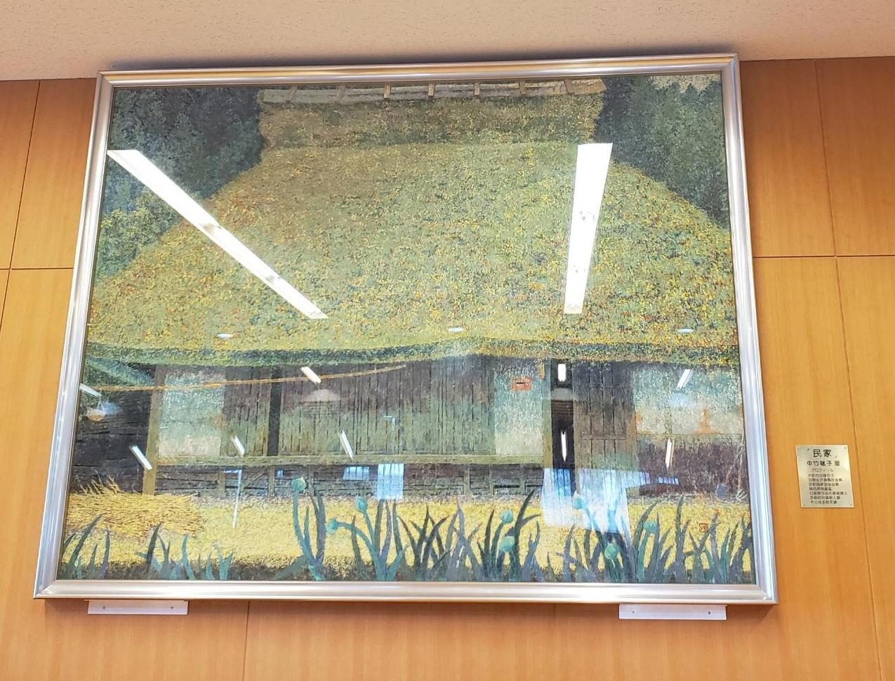 茅葺の民家の絵画が壁に飾ってある