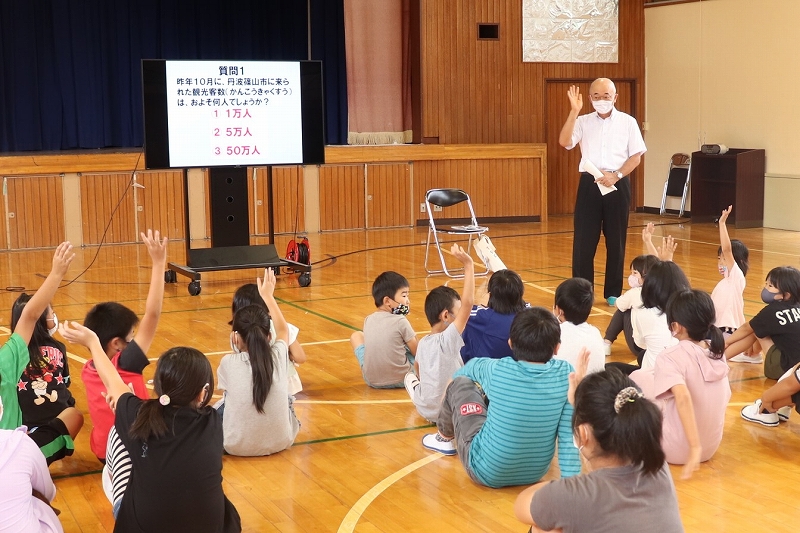 体育館で市長がクイズを出していて、子ども達が手を上げている。