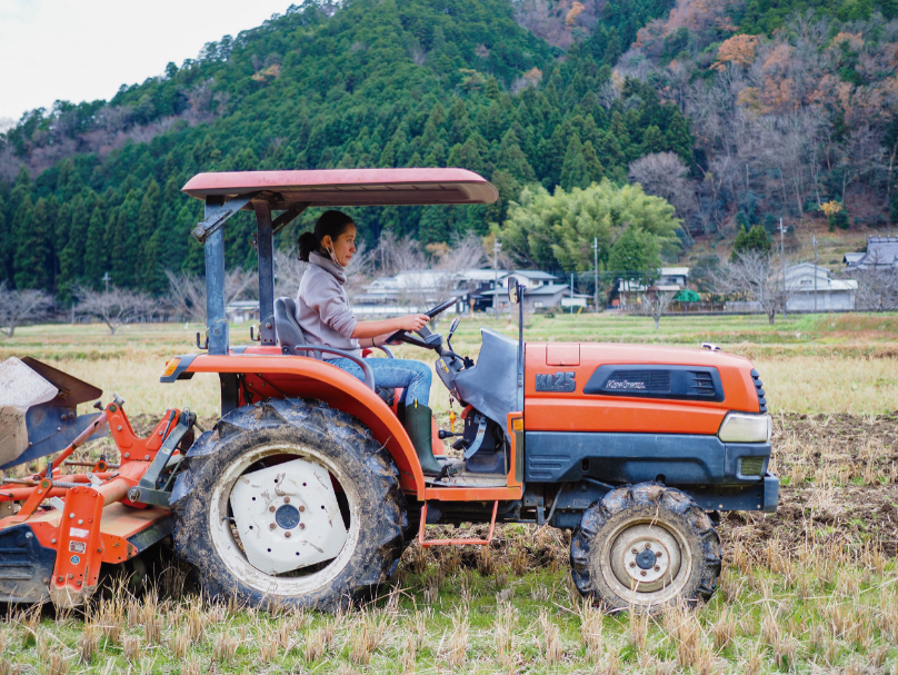 女性がトラクターを運転している