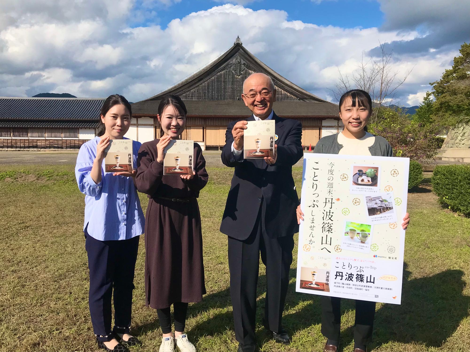 大書院の前で市長と女性職員2人がことりっぷを持っていて、もう一人の女性職員が宣伝のプレートを持っている