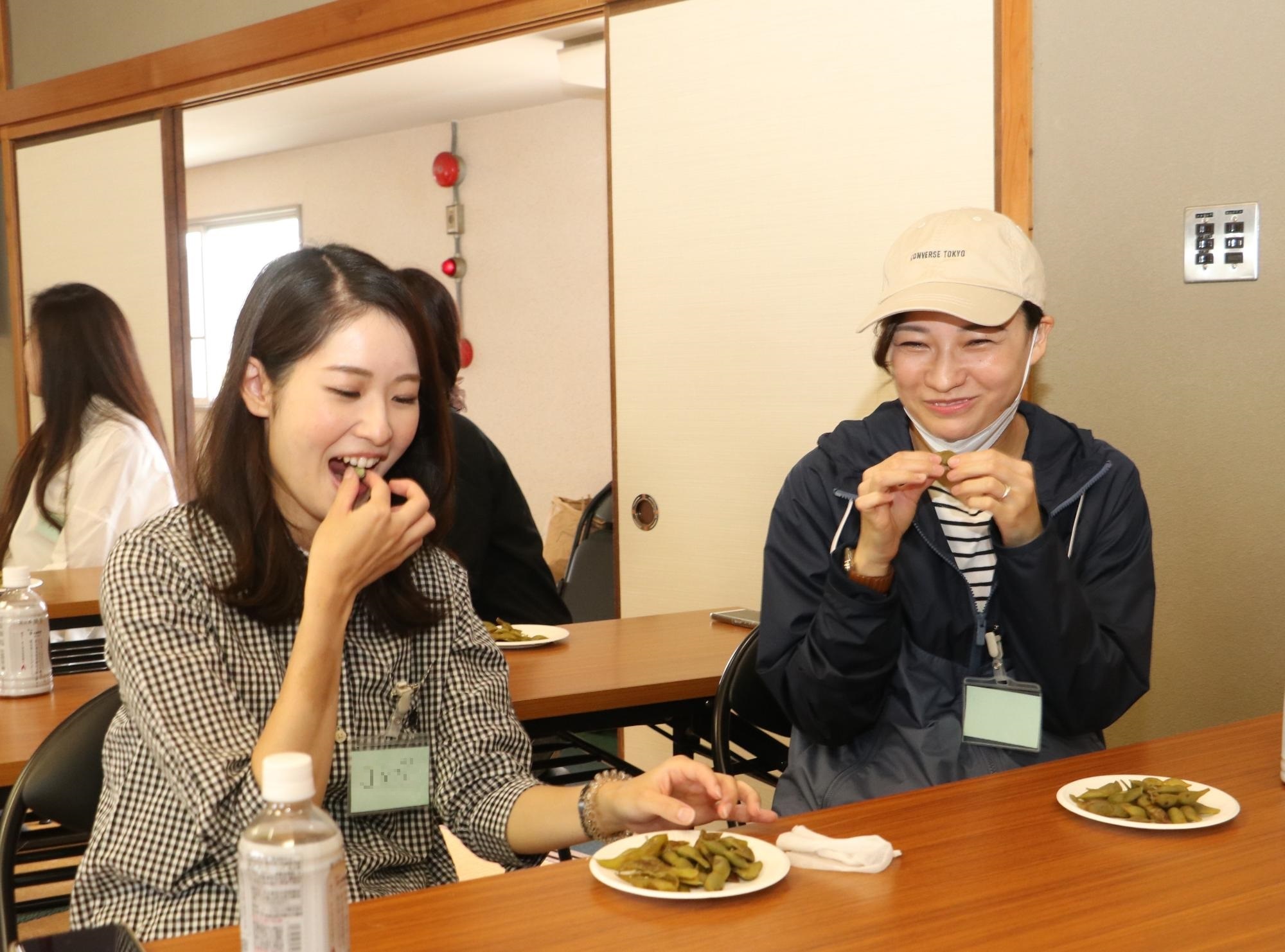 ゆでた黒枝豆をおいしそうに食べている女性たち