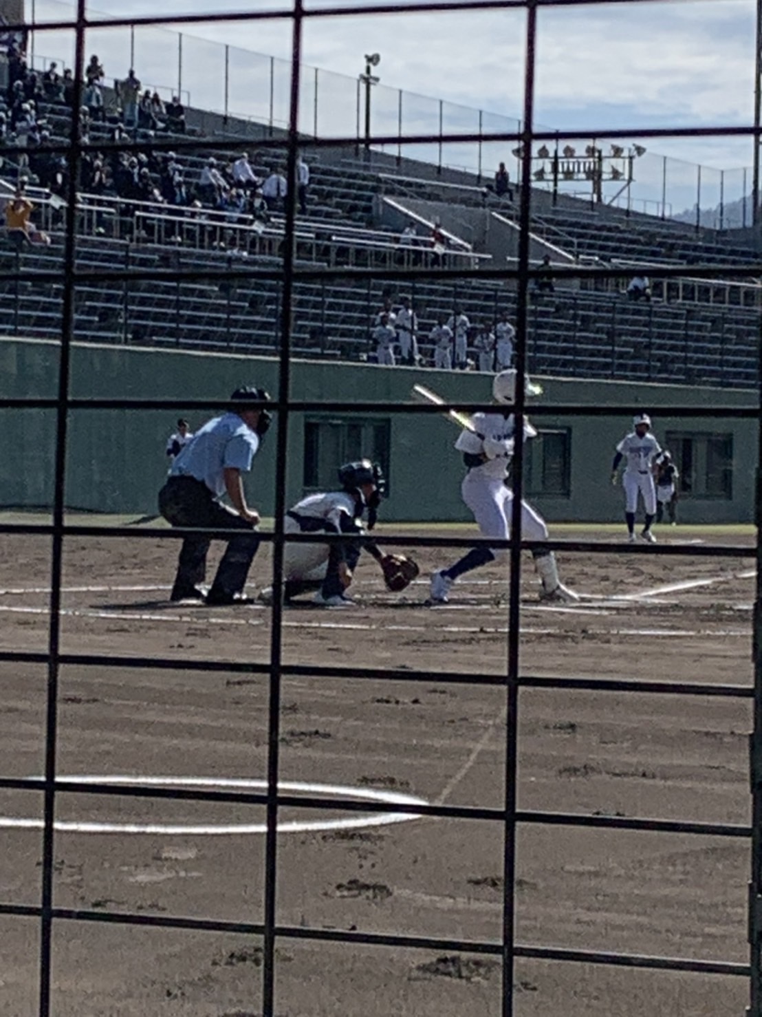 バックネット裏から、野球の試合を見ている。