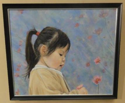 黄色のスモッグを着た女の子が花畑で花を摘んでいる