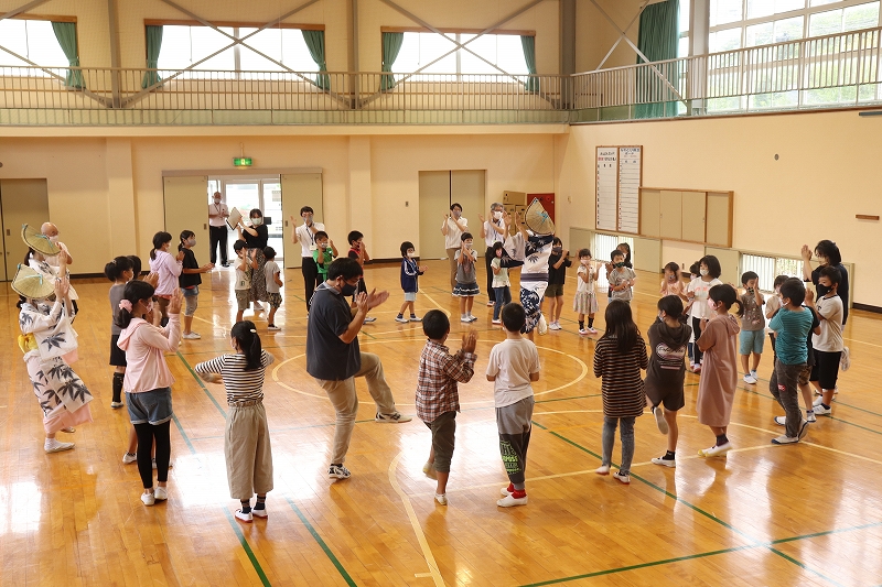 体育館で子どもたちと市長が輪になってデカンショ踊りを踊っている
