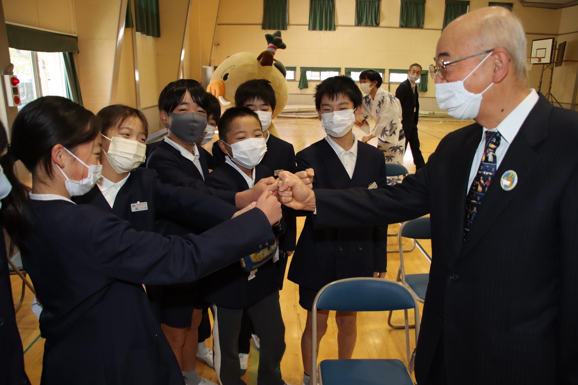 市長とこどもたち数人がグータッチをしている