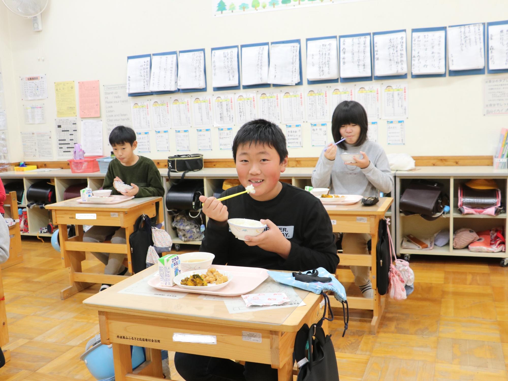 教室で給食を食べているこどもたちの写真