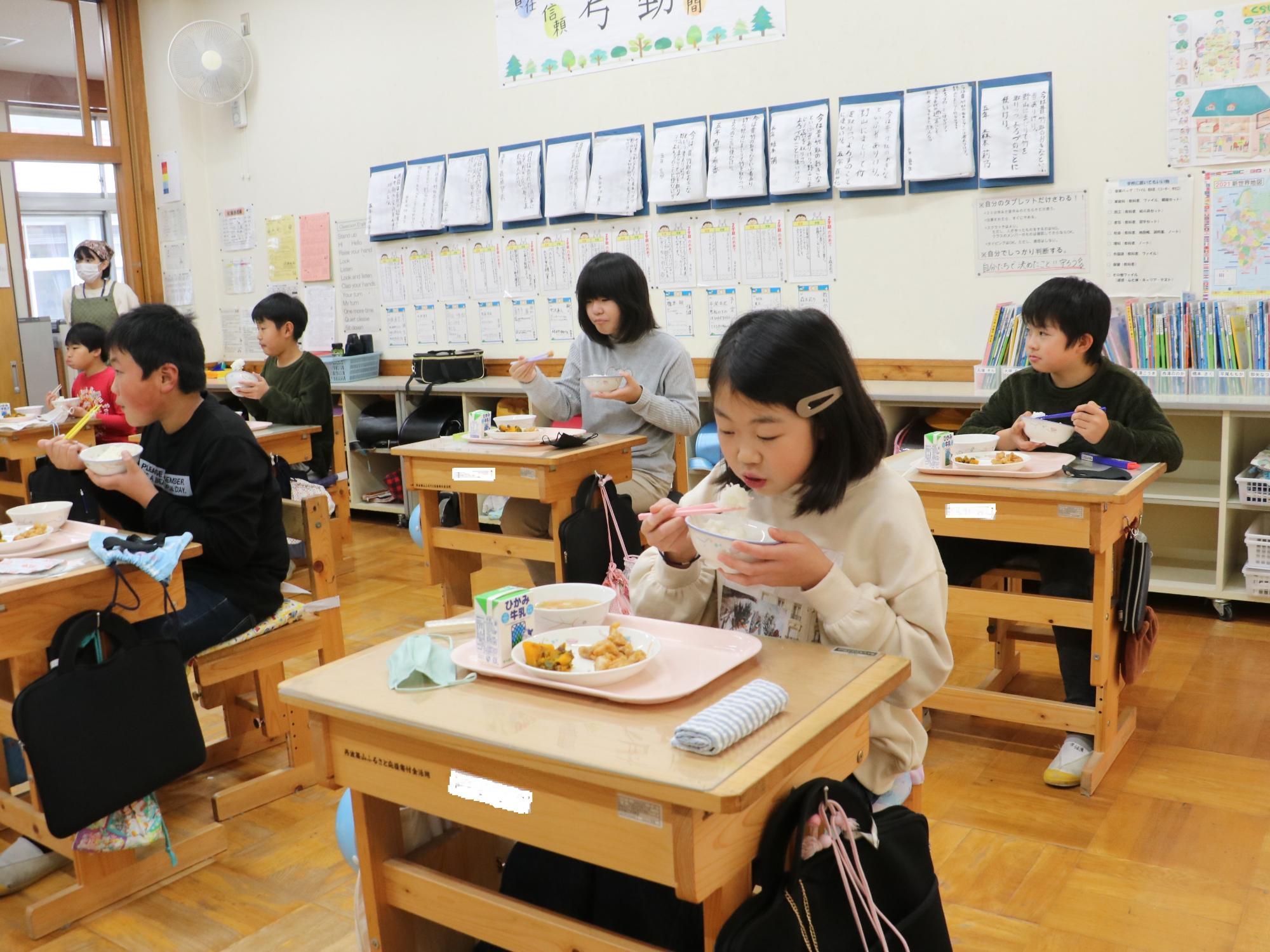 教室で給食を食べているこどもたちの写真