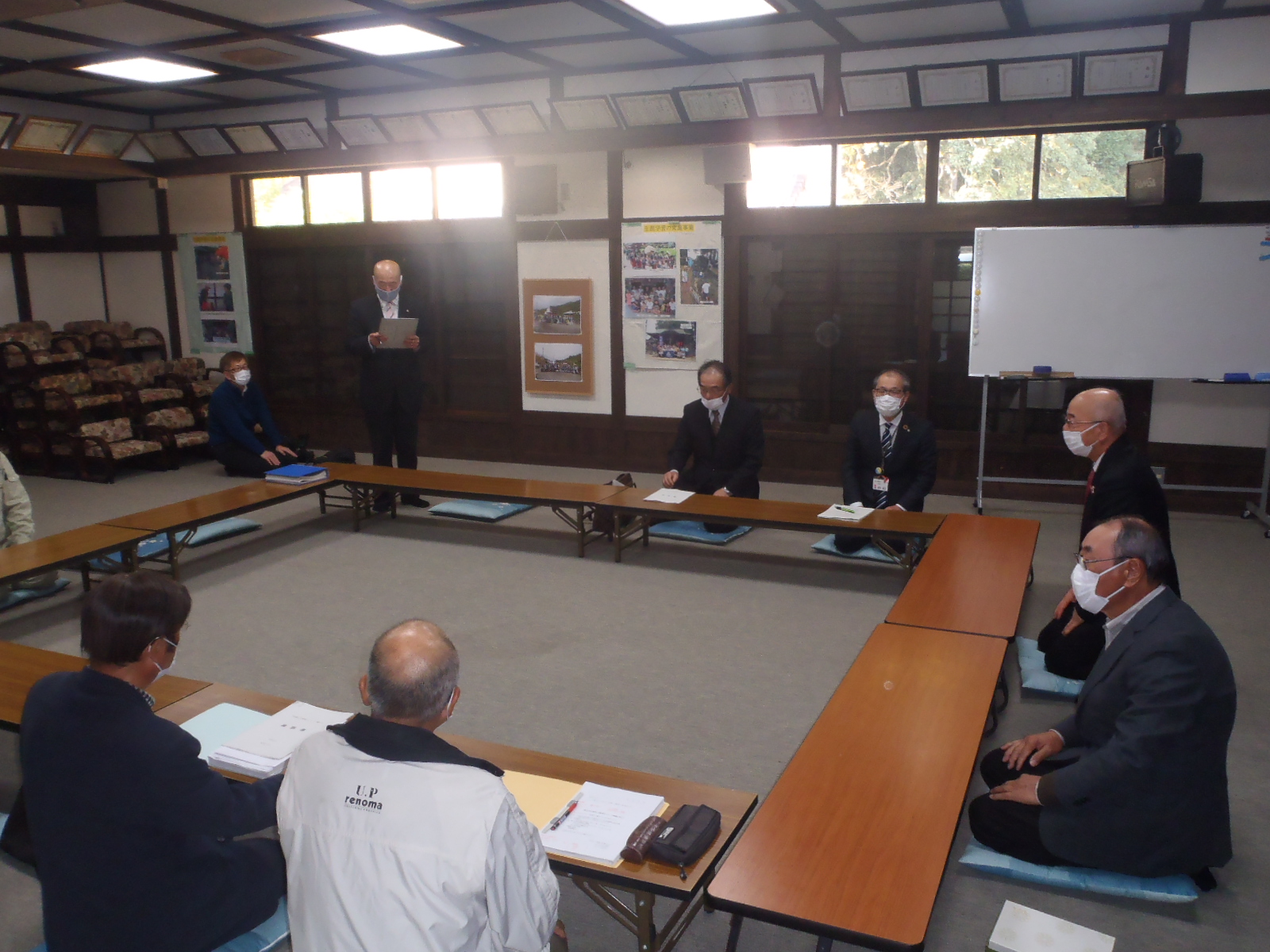 会議で職員があいさつしている