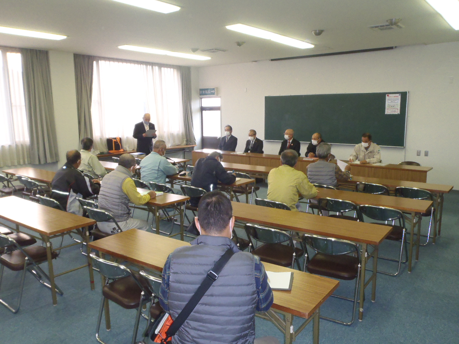 会議で職員があいさつしている