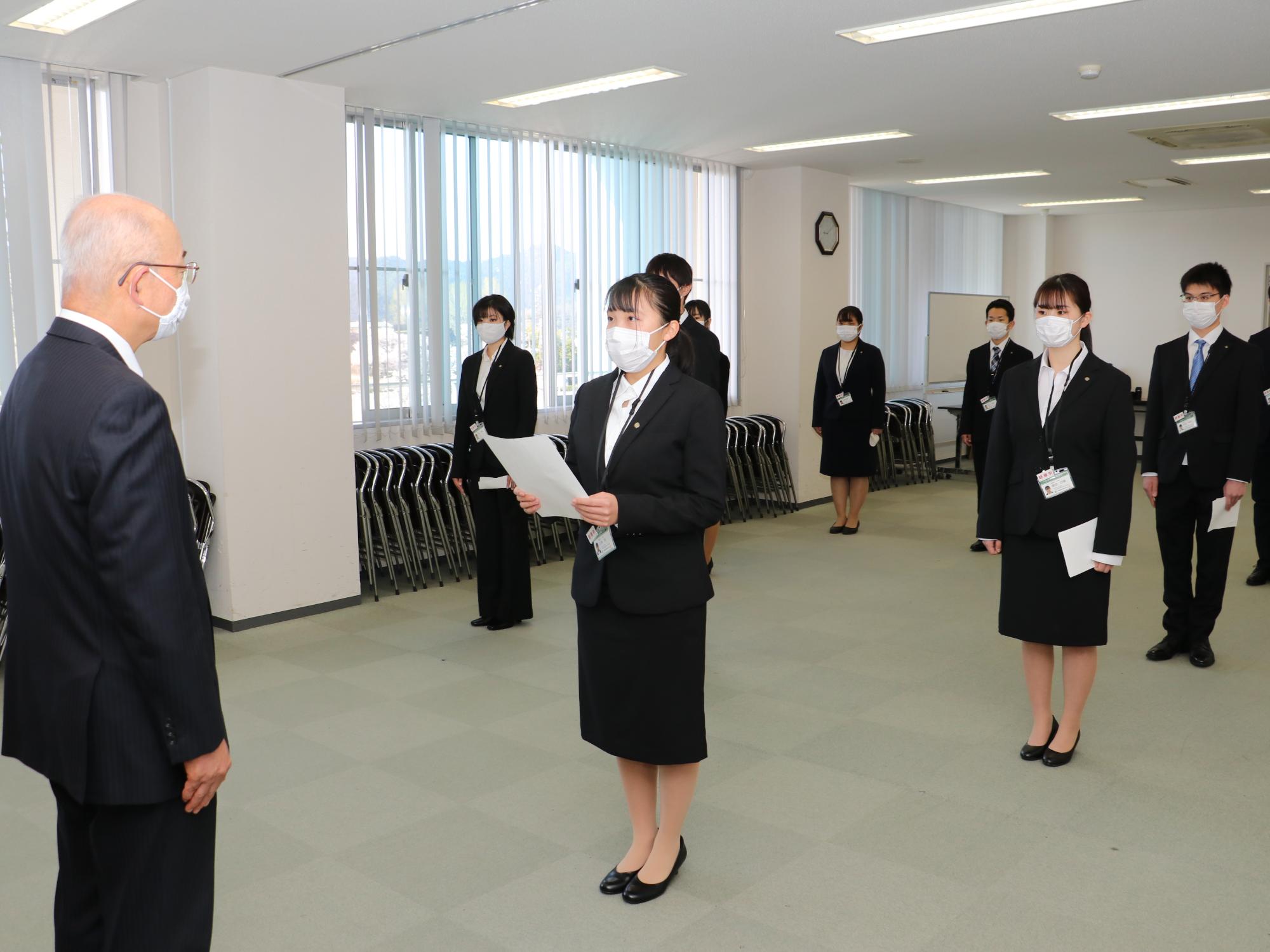 女性職員が手に持った紙を見ながら市長に話している