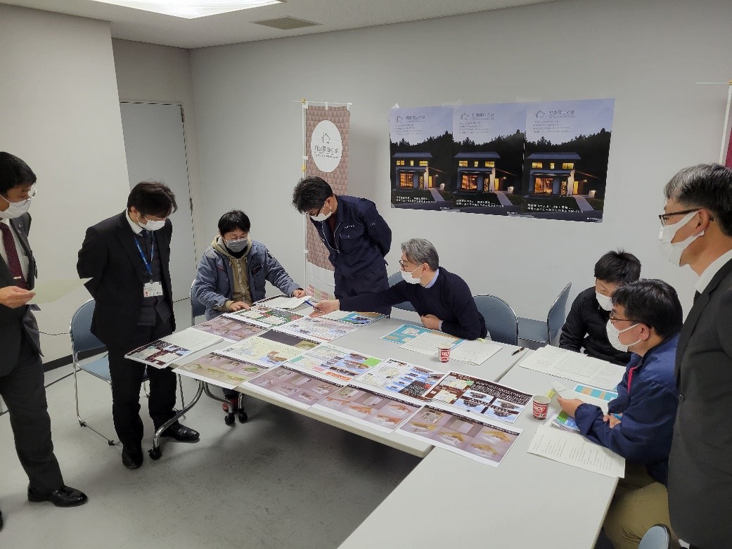 机に書類が並べてあって審査員たちが協議している