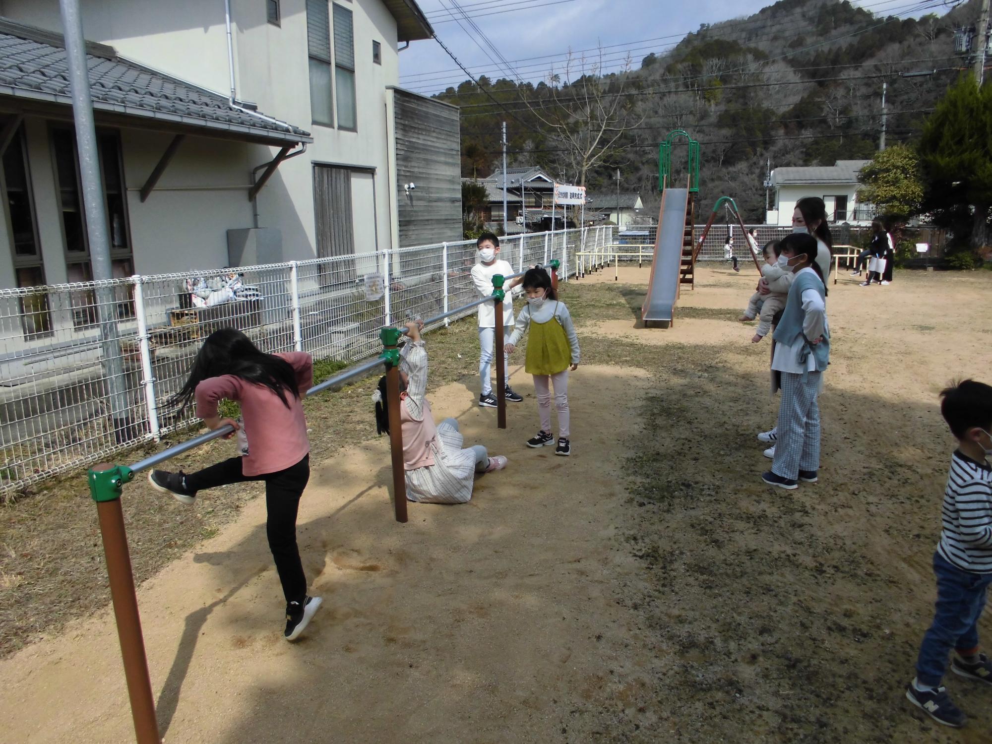 鉄棒でこどもたちが遊んでいる