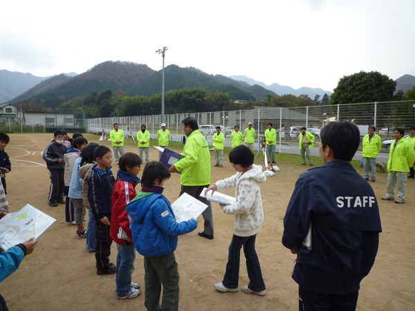 児童が測量会社の方からクリアファイルをもらっている写真