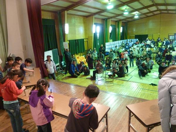 ステージで豆を箸でうまく掴めるかの競技が行われている様子の写真