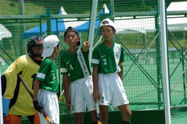 ユニフォームに4の数字が入っている少年が、5の数字の入った少年に指示を出している写真