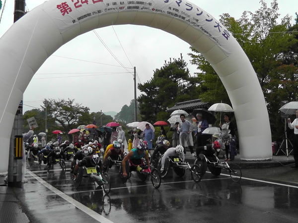 小雨の降る中、車椅子マラソンがスタートした瞬間の写真
