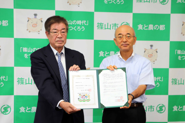 布亀株式会社の方と市長がささやまマメに見守り隊の協定書を持って記念撮影している写真