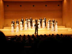 「ザ・タロー・シンガーズ」が舞台の上で合唱している写真