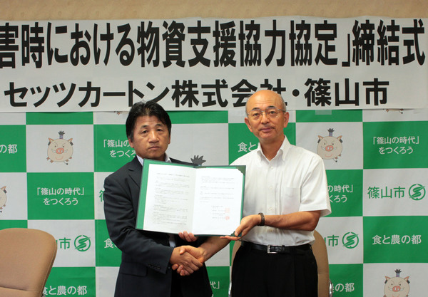 市長とスーツを着た男性が協定状を持ち、握手をしている写真