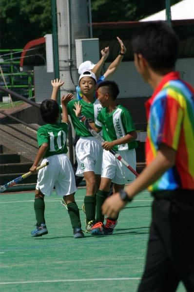 3人の少年たちがハイタッチをしようとしている写真