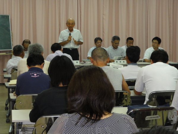 着席する沢山の男女の前で、マイクを持ち、立って話をする市長の写真